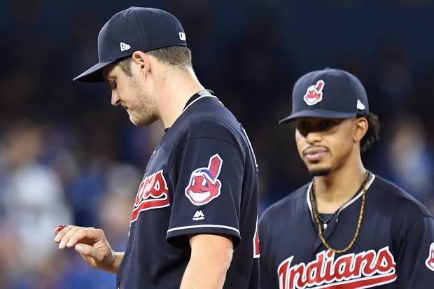Cleveland Indians starting pitcher Trevor Bauer, left, and teammate Francisco Lindor look at his bleeding finger during first inning game three American League Championship Series baseball action against the Toronto Blue Jays in Toronto on Monday, October 17, 2016