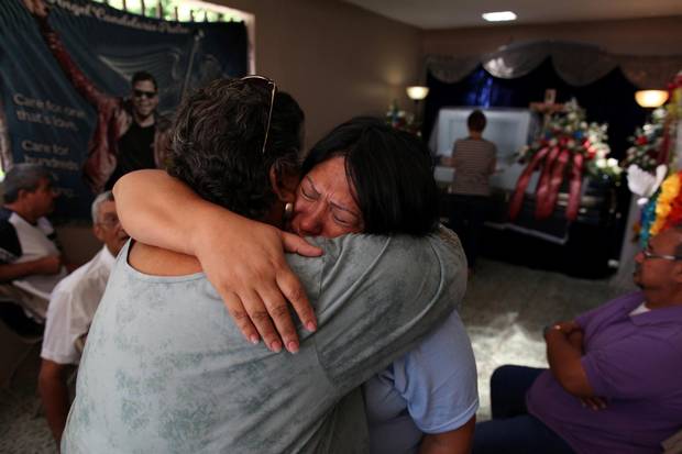 The body of Angel Candelario, one of the victims of the shooting at the Pulse night club in Orlando, lies in a coffin as family and friends mourn at his wake in his hometown of Guanica, Puerto Rico, on June 17, 2016.