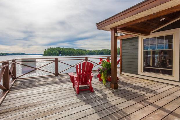Muskoka chairs sit on the deck of the boathouse, which features its own living quarters.