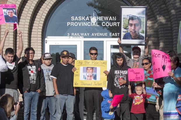 Family, friends and supporters of Colten Boushie hold signs during a rally outside of the Saskatchewan Provincial Court in North Battleford, Sask. on Aug. 18.