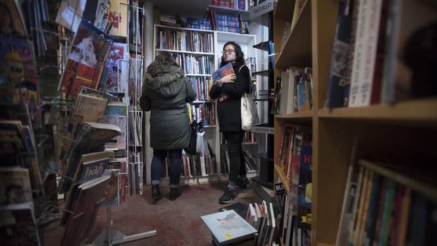 Nicole Kim (right) and her friend Lisa Benedetto browse the shelves for books while shopping at The Beguiling.