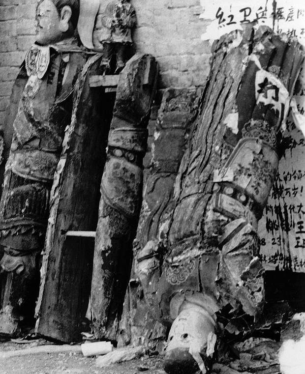 Wooden religious statues from a Buddhist temple lean against a temple wall in a Beijing suburb in August, 1966, after the Red Guard – setting out to destroy the “old superstitions of old China” – knocked the statues off their pedestals.