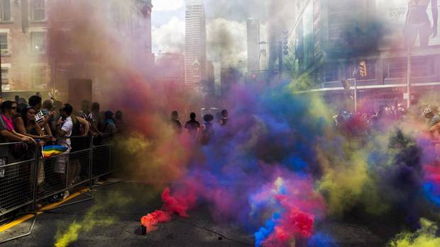 Members of the Black Lives Matter movement stand amidst coloured clouds from smoke grenades at the 2016 Pride Parade in Toronto.