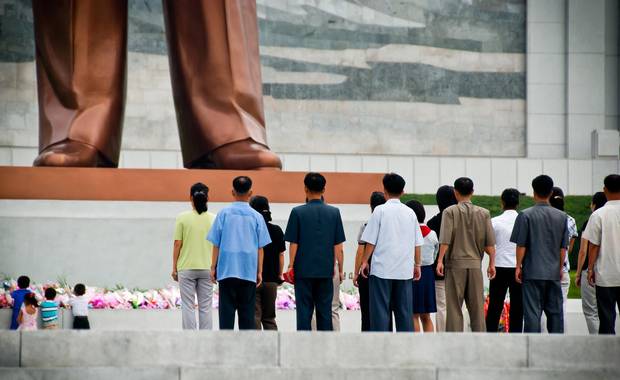 Visitors stand at the base of the Mansudae Grand Monument outside the Korean Revolution Museum.