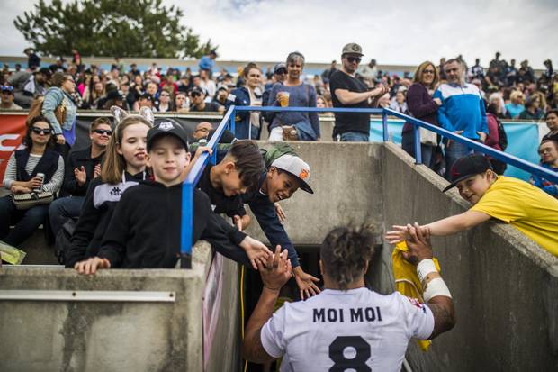 Fans give Toronto Wolfpack player Fui Fui Moi Moi high fives during halftime.