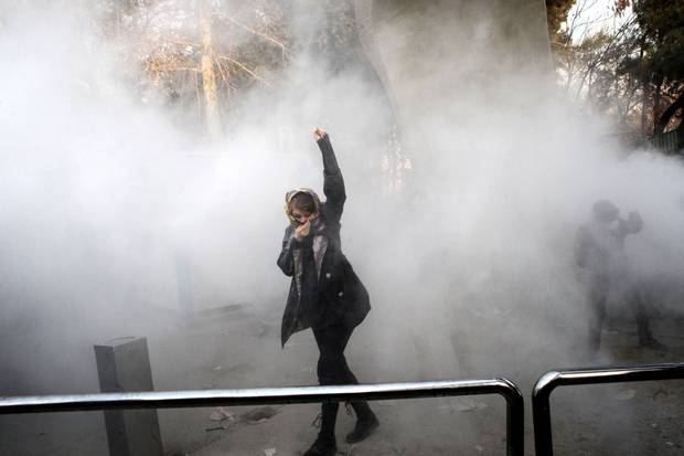 Dec. 30, 2017: An Iranian woman raises her fist amid the smoke of tear gas at the University of Tehran during a protest driven by anger over economic problems.