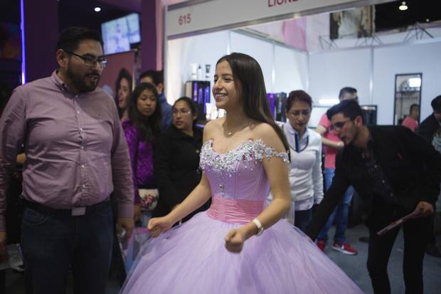 Fernanda Castro, a 14-year-old from Guerrero, Mexico, models an Amaraby dress for her family at 15Fest. Fernanda has decided this is the one. 