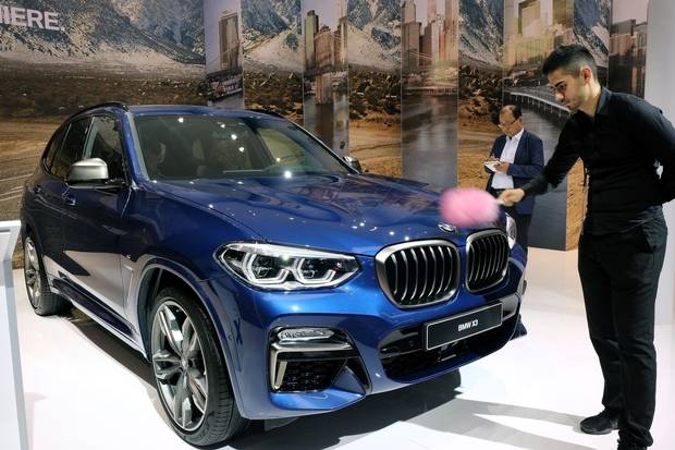 FRANKFURT AM MAIN, GERMANY - SEPTEMBER 13: A man cleans at BMW X3 car at the 2017 Frankfurt Auto Show 'Internationale Automobil Ausstellung' (IAA) on September 13, 2017 in Frankfurt am Main, Germany. The Frankfurt Auto Show is taking place during a turbulent period for the auto industry. Leading companies have been rocked by the self-inflicted diesel emissions scandal. At the same time the industry is on the verge of a new era as automakers commit themselves more and more to a future that will one day be dominated by electric cars. (Photo by Thomas Lohnes/Getty Images)