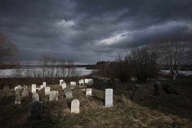 Headstones, including those of other soldiers who served in the armed forces, rest near Church Cove behind St. Peter’s Parish in Tracadie, N.S.