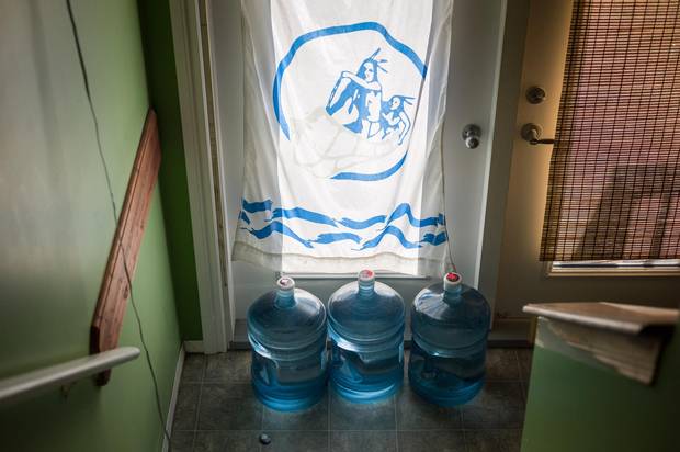 Containers filled with drinking water in the entrance of a home in Fort McKay, Alta. While residents used to drink directly from the nearby Athabasca River, they can now not even consume the treated tap water.