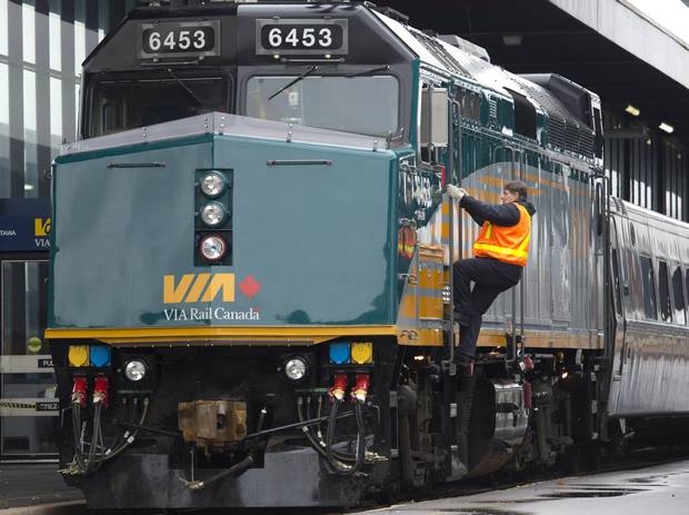 A Via Rail employee climbs aboard an F40 locomotive at the train station in Ottawa on Monday, December 3, 2012. Backbench MPs from the party that gave Canada its first transcontinental railroad appear to be in a losing, behind-the-scenes struggle over cuts at Via Rail, leaving some communities scrambling for new transit options.