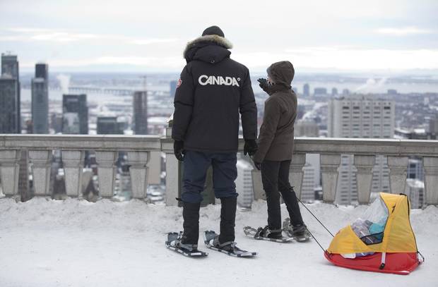 People look out at the city from Mont-Royal in Montreal. The skyline is becoming more crowded as new towers are erected.