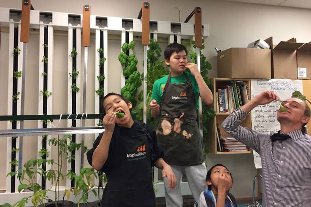 Students and teacher Michael Valk enjoy the leafy greens they’ve grown in their plant towers at Kugluktuk High School in Nunavut.