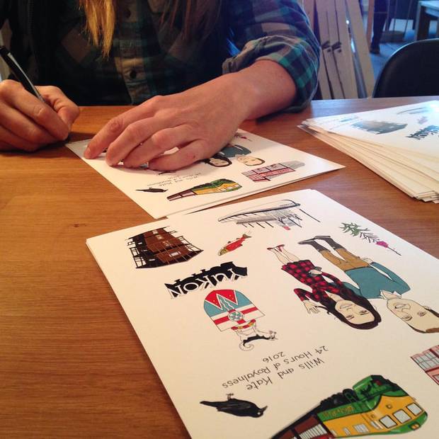 Illustrator Monika Melnychuk signs copies of the prints she made for Collective Good