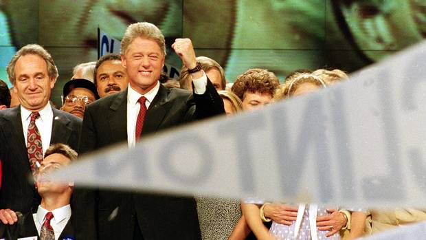 Bill Clinton, also seen on the large screen behind him, raises his fist in victory after giving his acceptance speech for his party's nomination at the Democratic National Convention in New York City on July 16, 1992.
