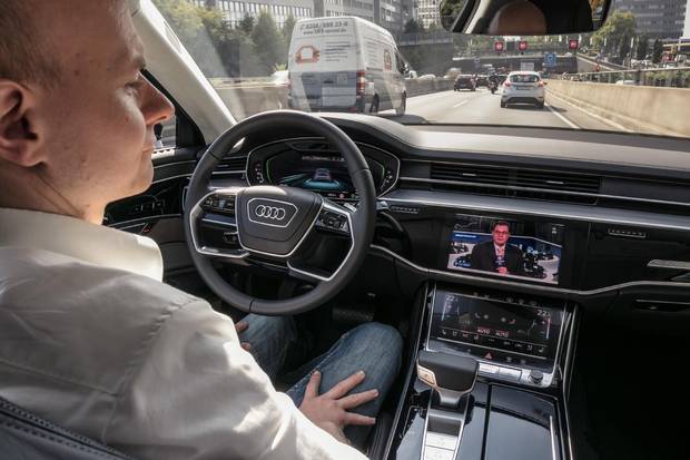Watching the news while the Audi A8 pilots itself in traffic.
