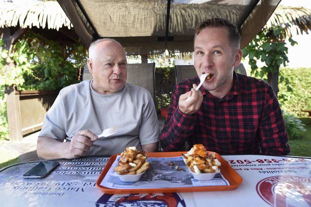 Globe and Mail writer Justin Giovannetti, and his father Larry Lamothe, tuck into their orders of poutine at he Cantine W in Warwick, Que.