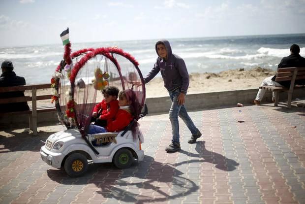 Mahand Salama, 13, hires out his toy car for children to enjoy a ride at the Seaport of Gaza City. Salama, whose father is unemployed, charges one shekel ($0.25) per ride and earns around 25 Shekels ($6.40 U.S.) per working day. He and his two brothers are the main breadwinners of their family. He hopes to be a doctor as he still goes to school.