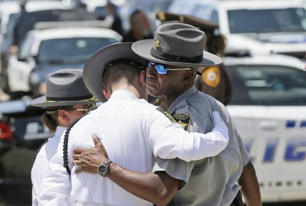 Law enforcement officers comfort each other after the funeral services for Dallas Police Sr. Cpl. Lorne Ahrens at Prestonwood Baptist Church in Plano, Texas.