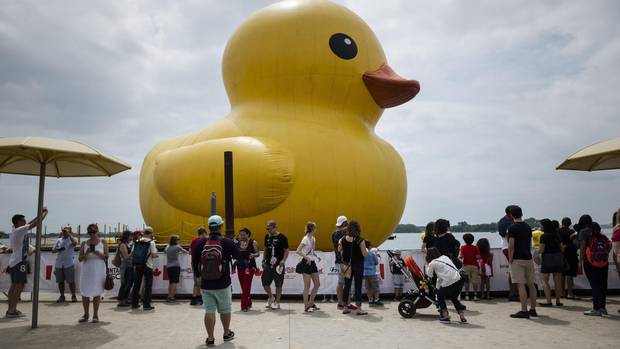 People celebrate Canada Day near the giant inflatable duck that sits on Toronto's Harbourfront on Saturday, July 1, 2017. 