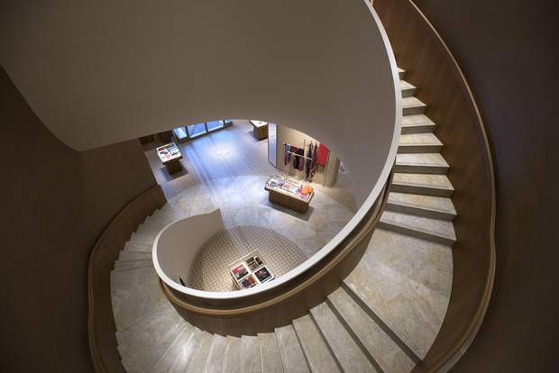 The winding grand stairs, with handrails covered in baby-calf leather, that take shoppers from the main floor to the second level of Hermès's Toronto store.