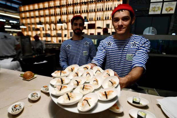 Fishmongers present fish dishes at a stand during a press tour at FICO Eataly World agri-food park in Bologna on November 9, 2017. FICO Eataly World, said to be the world's biggest agri-food park, will open to the public on November 15, 2017.