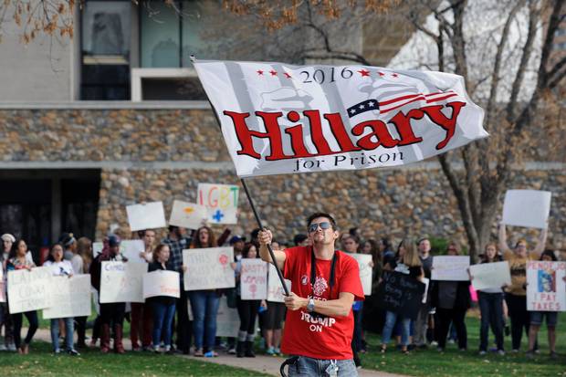 A Trump supporter waves an anti-Clinton flag as pro-Clinton supporters demonstrate behind him outside the the Bank of Colorado Arena on the campus of University of Northern Colorado on Oct. 30, 2016.