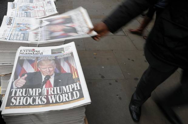 A passerby takes a copy of the Evening Standard in London on Nov. 9, 2016.