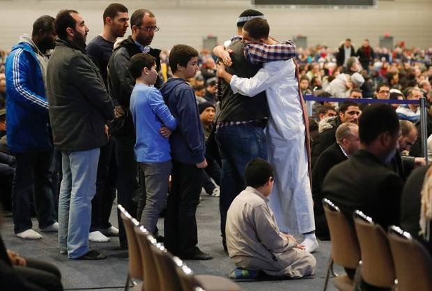 Mourners embrace during funeral services for three of the victims of the mosque attack, at the Congress Centre in Quebec City, Feb. 3, 2017.