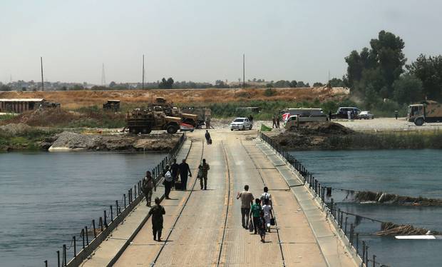 Iraqis cross a bridge connecting west and east Mosul on July 13, 2017, a few days after the government's announcement of the ‘liberation’ of the city from Islamic State fighters.