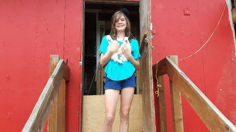 Lisa Kadane’s daughter Avery holds silkie chickens at Blind Tiger Vineyards.