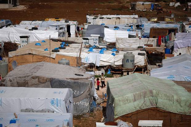 Syrian refugees stand outside their tents at a Syrian refugee camp in the town of Hosh Hareem, in the Bekaa valley, east Lebanon, Wednesday, Oct. 28, 2015.