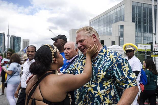 A parade participant greets Doug Ford during the Grand Parade at the Caribbean Carnival in Toronto in August.