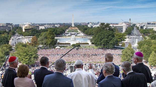 Pope Francis waves to the assembled crowd from the Speakers Balcony at the U.S. Capitol with members of Congress, Thursday, Sept. 24, 2015, in Washington after he addressed a joint meeting of Congress.