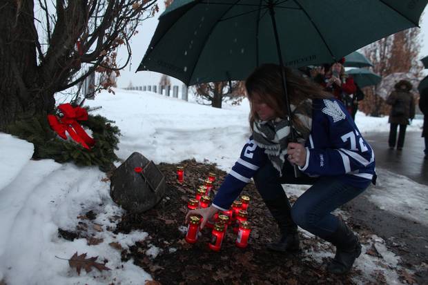 Lisa McBain places a candle for her late brother Corp. John Unrau during a candlelight ceremony to honour the memory of Soldiers of Suicide (S.O.S.) at the National Military Cemetery of the Canadian Forces at Beechwood Cemetery Feb. 21, 2017 in Ottawa. 