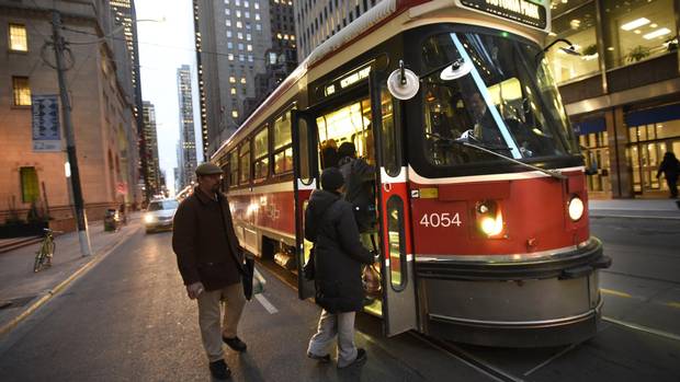 Commuters board an eastbound King Street streetcar at Yonge Street in Toronto.