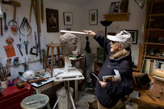 Frances Gage demonstrates her clay-application technique on a bust of Owen Hellum, in her studio in Cobourg, ON in 2009.