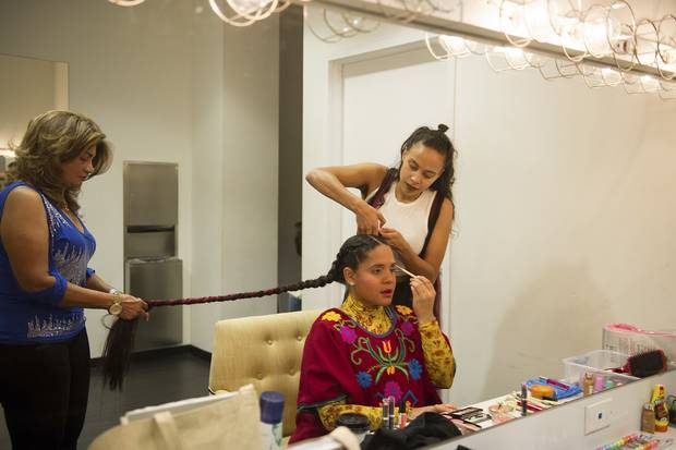 Lido Pimienta has her hair done by her mother, Rosario Paz, left, and friend and artist Ruth Titus, right, before her set at Venus Fest.
