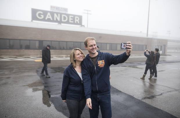 David Hein, left, and Irene Sankoff, the husband-and-wife writing team behind the musical Come From Away, hold take a selfie on the tarmac of the Gander International Airport in Gander, N.L