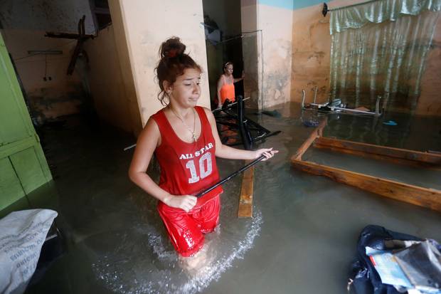 Havana, Sept. 10: A woman reacts while wading through her flooded home after Irma’s passing.