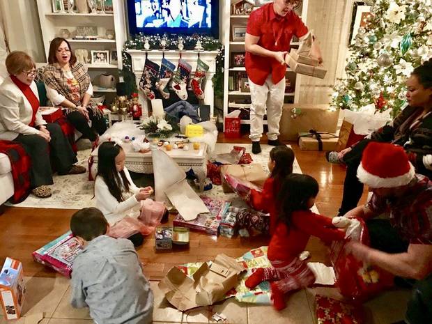 photos from Carol Gomez and her family's holiday traditions. Children opening presents at the end of the evening.