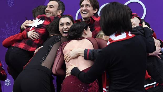 Canada's athletes hug after they won the figure skating team event title during the Pyeongchang 2018 Winter Olympic Games at the Gangneung Ice Arena in Gangneung, on Feb. 12, 2018.