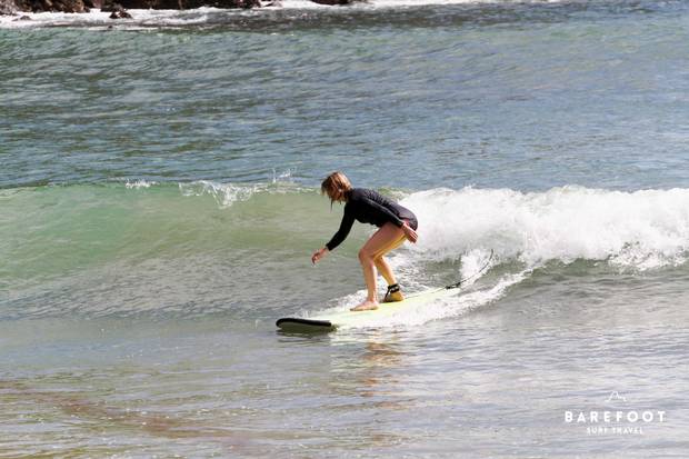 Riding a wave at surfing camp.