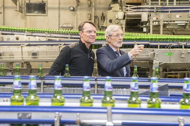 Andrew Oland, president of Moosehead Breweries, left, and father Derek Oland, check on the operations of the packaging line.