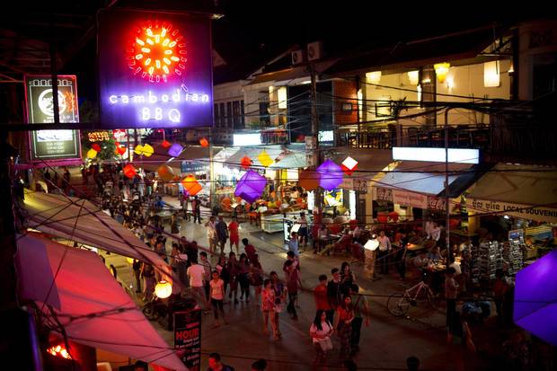 Tourists walk past restaurants and bars on Pub Street at night in Siem Reap.