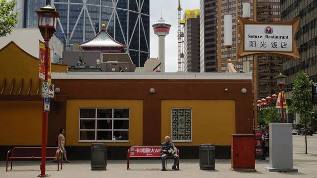 A man rests on a bench in Calgary's Chinatown.