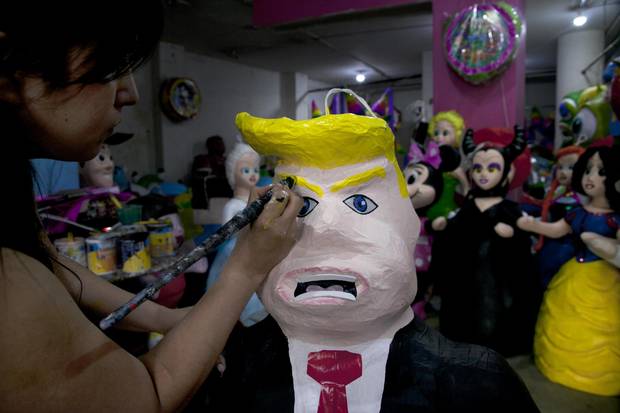 Alicia Lopez Fernandez paints a pinata depicting Donald Trump at her family's store 