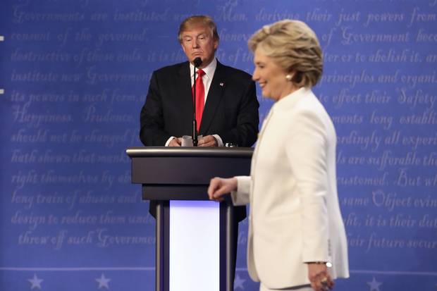 Donald Trump waits behind his podium as Hillary Clinton makes her way off the stage after the third presidential debate at UNLV in Las Vegas on Oct. 19, 2016.