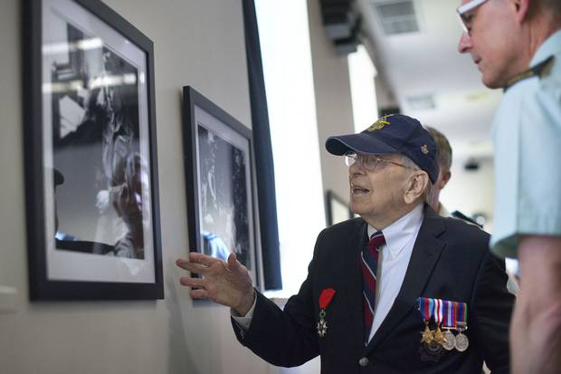Second World War veteran Jack Ford looks at photographs on display at the Canadian Forces College with the college’s commandant, Brigadier-General K.R. Cotten. Mr. Ford, 92, was with the 414 Photo Unit Squadron. He took many of the photographs on display and he developed and printed many more from cameras that were set up in Spitfire fighter planes.