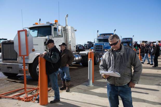 Dave Kuchera keeps an eye on selling prices as semi trucks go up for bidding during an auction at Ritchie Bros. in Nisku.